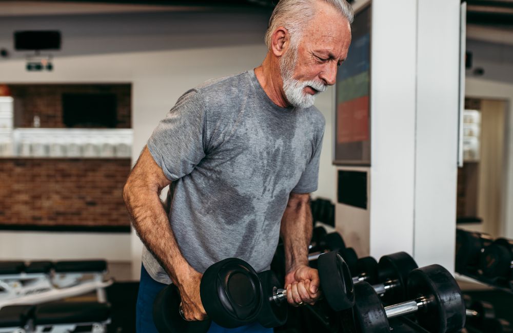 Senior man exercising at gym.